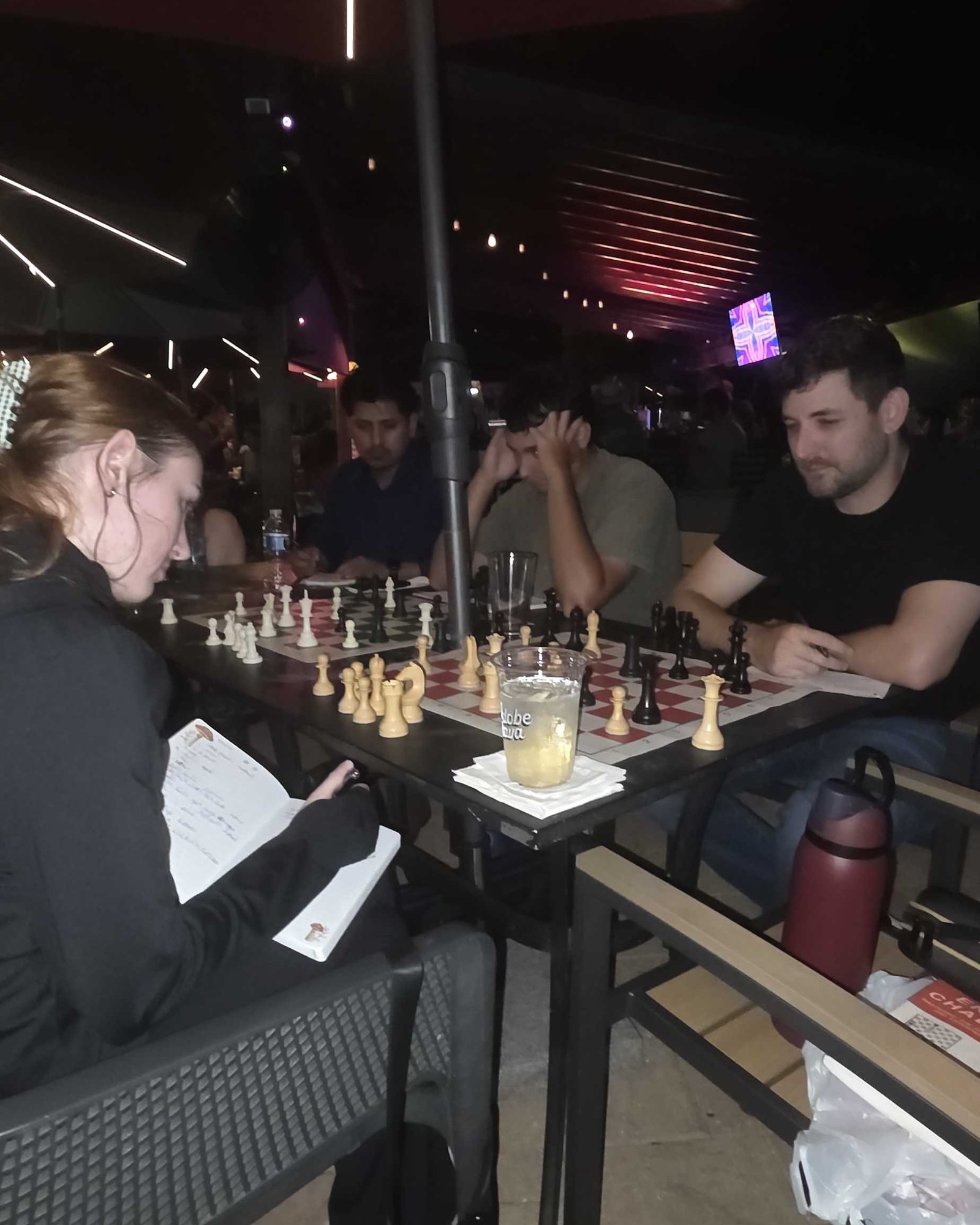 Jugadores en los tableros bajo las luces de la sombrilla en Adobe Kava en una noche de estudio intermedio de jueves