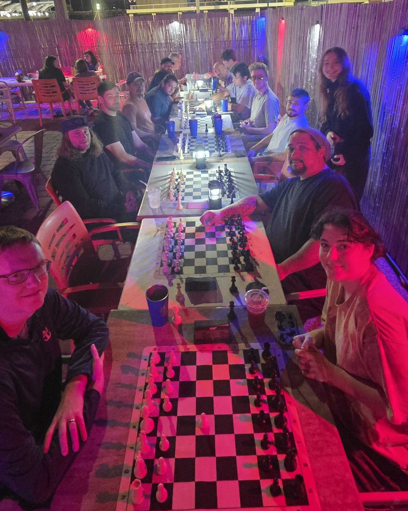 League night two of season 10 at Kava Social Club: a long table of boards down the patio, eighteen players under the red and blue lights