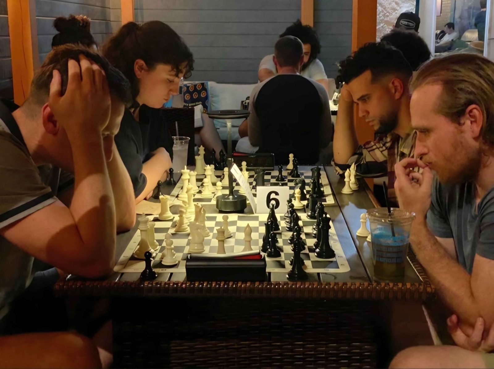 Four players deep in thought over board 6