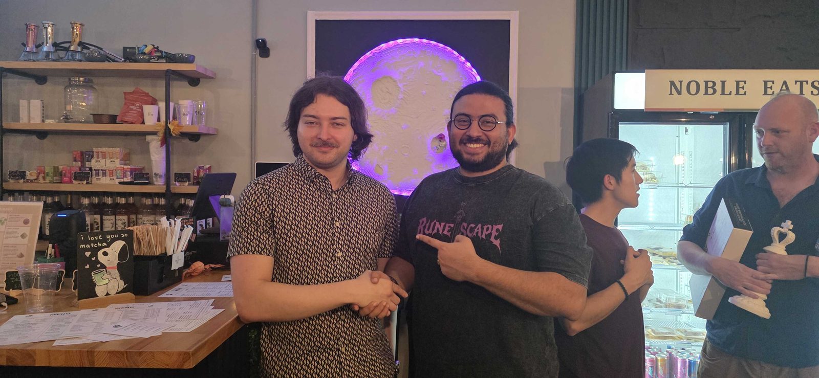 Two players shaking hands at the counter after the match