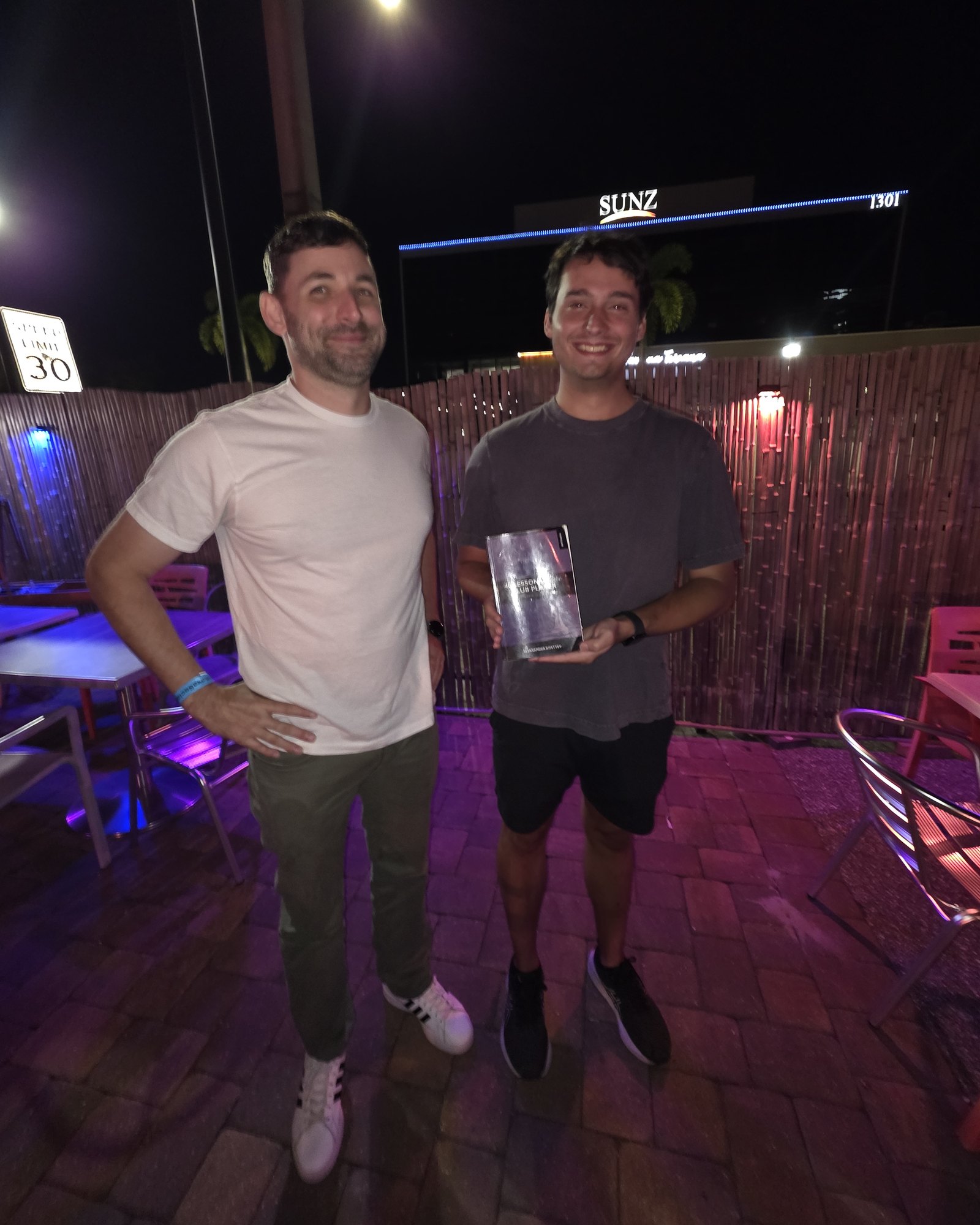 Brian, on the left, and Mathew, on the right holding 40 Lessons for the Club Player, on the back patio at Kava Social