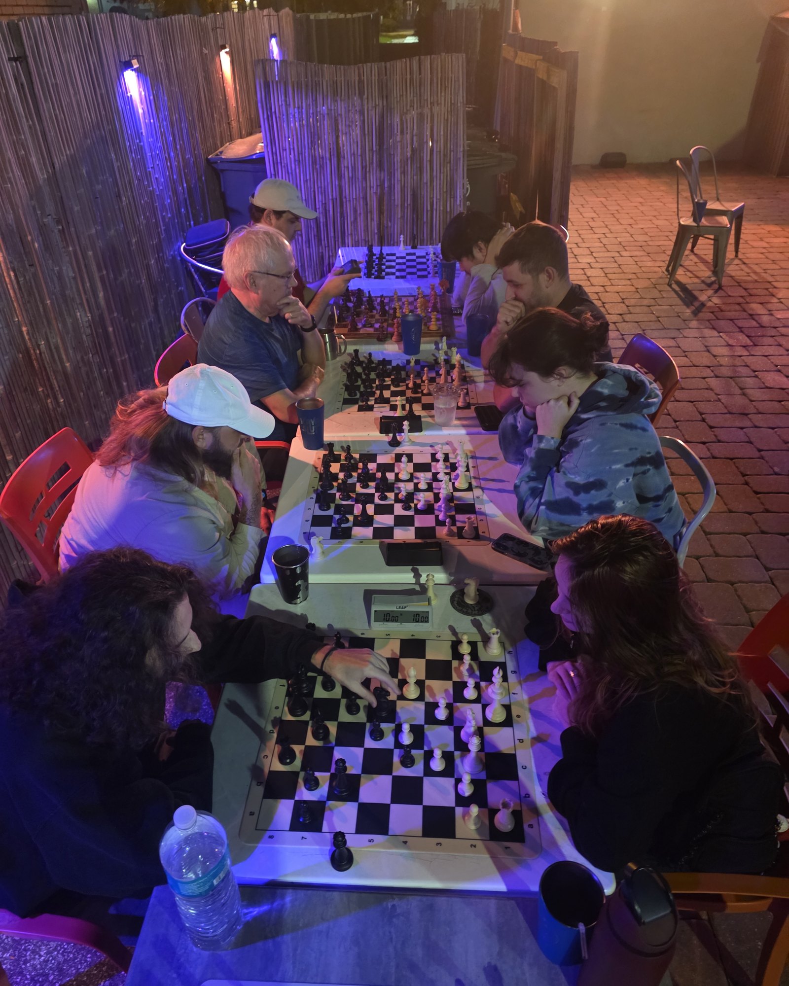 Players deep in their games along the long tables on the patio at Kava Social on a Tuesday study night