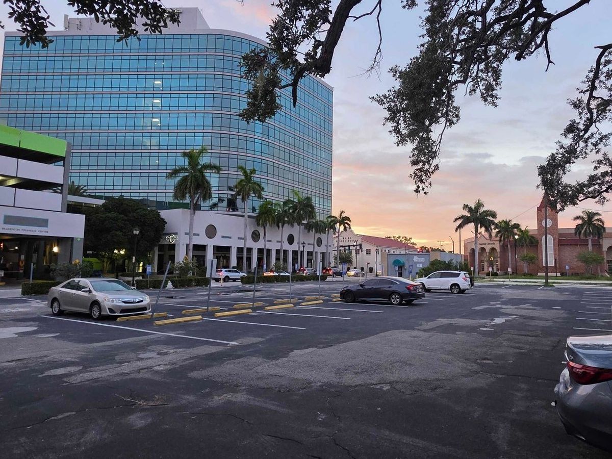 The large open parking lot off S Tamiami Trail in downtown Bradenton at sunset, with a few cars parked