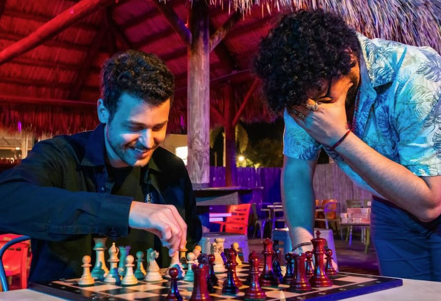 Two members mid-game on a club night, one with his head in his hands, both grinning